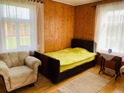 a bedroom with a bed and a chair and window at Treimani Country House in Treimani