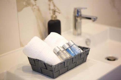 ein Korb mit Handtüchern und Zahnbürsten auf einem Waschbecken in der Unterkunft Hotel Paradise Punta in Nečujam