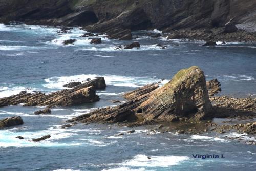 a view of the ocean with rocks in the water at Apartamentos rurales la Aguilera in Oviñana