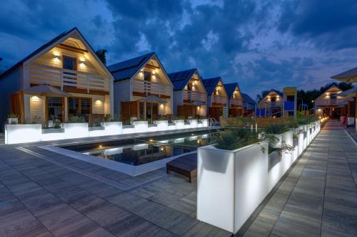 a villa with a swimming pool at night at Natural Resort in Gąski