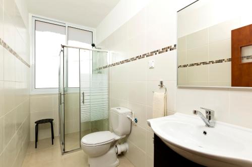 a bathroom with a toilet and a sink and a shower at Home4Trip Bat Yam in Bat Yam