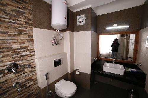 a bathroom with a toilet and a sink and a mirror at Buddha Retreat in Ravangla