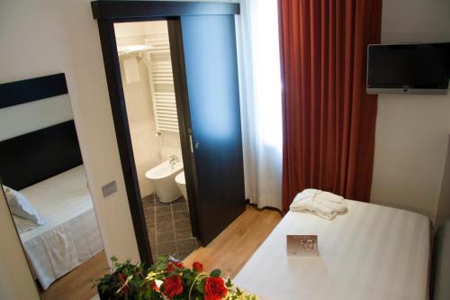 a room with a bed and a bathroom with a mirror at Card International Hotel in Rimini
