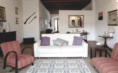 a living room with a white couch and two chairs at Bosa Exclusive Apartments "Bosa Apartments" in Bosa