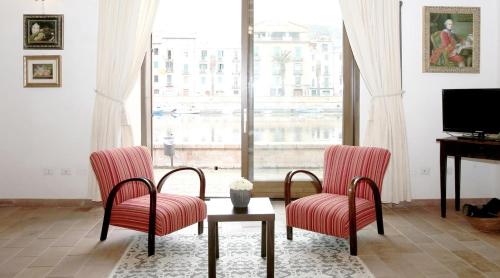 a living room with two chairs and a table and a television at Bosa Exclusive Apartments "Bosa Apartments" in Bosa