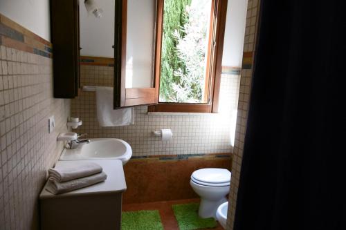baño con aseo y lavabo y ventana en Casa Mare, en Balestrate