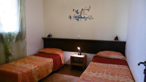 Habitación con 2 camas con sábanas de color naranja en Casa Mare, en Balestrate