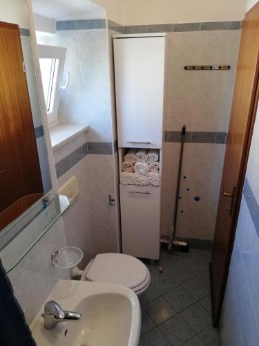 a small bathroom with a toilet and a sink at Apartment Luka in Mali Lošinj