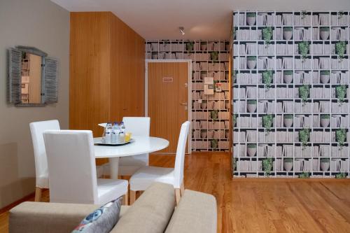 a dining room with a table and white chairs at Casas do Teatro in Porto