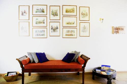 an orange couch in a room with pictures on the wall at Bosa Exclusive Apartments "Bosa Apartments" in Bosa