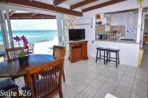 a kitchen and dining room with a table and a view of the ocean at Antigua Village Beach Resort in Saint Johnʼs