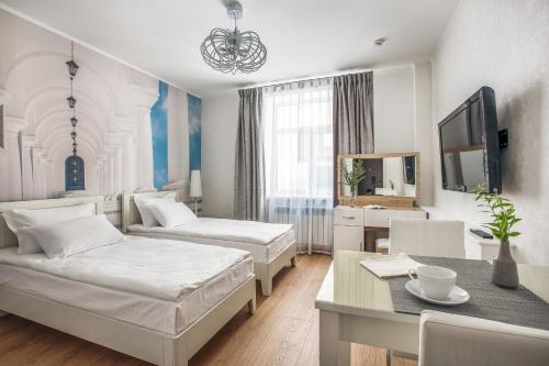 カザンにあるApart-Hotel on Pushkina 26のベッド2台とテーブルが備わるホテルルームです。