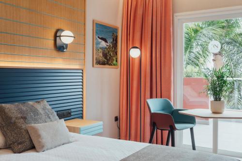 a bedroom with a bed and a table and a chair at Adrián Hoteles Roca Nivaria in Adeje