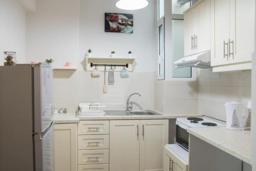 a white kitchen with a sink and a refrigerator at Cherry Apartment Corfu in Corfu