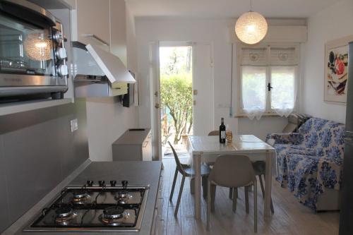 a kitchen with a stove and a table with a dining room at Le tre caravelle S Maria a soli 150m dal mare -WI-FI in Marina di Castagneto Carducci