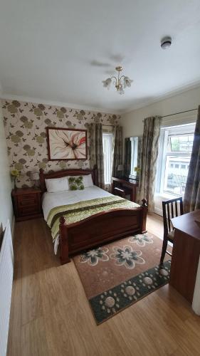 um quarto com uma cama, uma secretária e uma janela em Rose Park House em Derry Londonderry