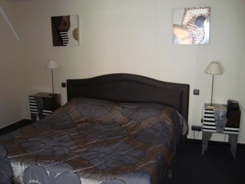 a bedroom with a bed and two lamps in it at Hôtel de La Croix d'Or in Avranches