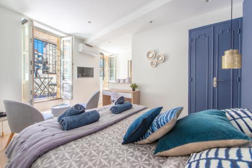 une chambre avec un grand lit avec des oreillers bleus dans l'établissement Place Du Pin, à Nice