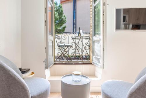 une chambre avec deux chaises, une table et un balcon dans l'établissement Place Du Pin, à Nice