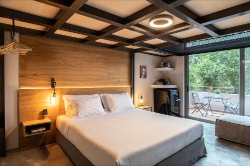 - une chambre avec un grand lit et un balcon dans l'établissement Bespoke House Athens, à Athènes