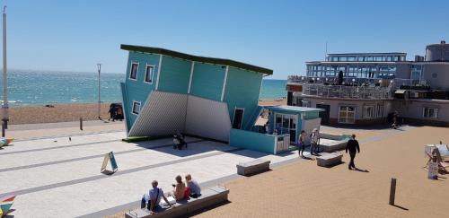 a group of people sitting around a building on the beach at Andorra Guest Accommodation in Brighton & Hove