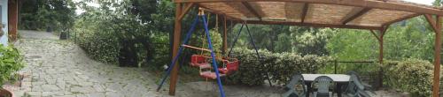 a swing set in a pavillion with a wooden structure at la casa sull'arcobaleno 1 in Manta
