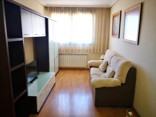 a living room with a couch and a television at Apartamentos Cocó in Avila