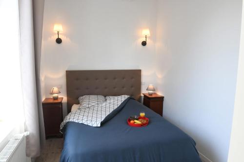 a bedroom with a bed with a bowl of fruit on it at La Grande Marée in Dieppe