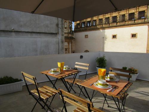 una mesa y sillas en un balcón con sombrilla en B&B San Michele, en Mazara del Vallo