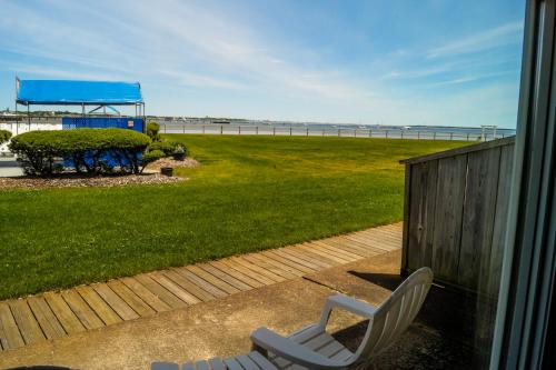 a white chair sitting on a porch with a view of the beach at Provincetown Inn in Provincetown