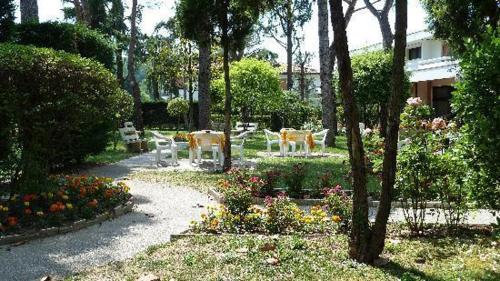 a cemetery with white chairs and flowers and trees at Hotel Terme Marconi in Montegrotto Terme