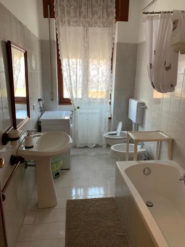 uma casa de banho com uma banheira, um lavatório e um WC. em Affittacamere Serravalle Shopping em Serravalle Scrivia