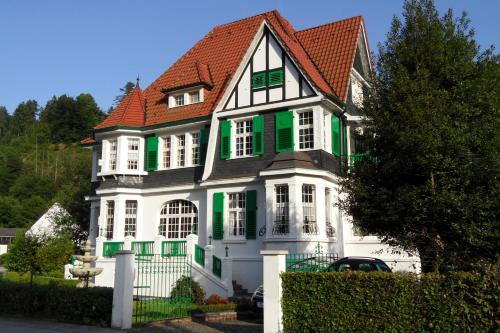 a large white house with green shutters at Villa Biso in Solingen