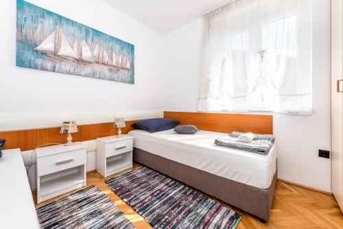 een kleine slaapkamer met een bed en een tapijt bij Luena in Grebaštica