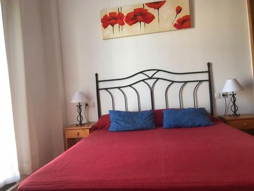 - une chambre avec un lit rouge et 2 oreillers bleus dans l'établissement Residencial Parque Azahar ll, à Alcossebre