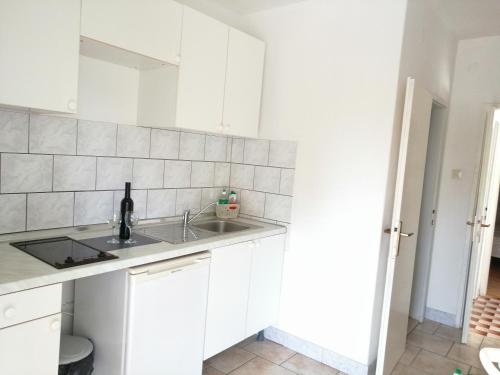 a kitchen with white cabinets and a sink at Apartments Kati in Orebić