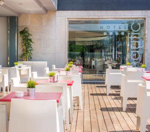 a restaurant with white tables and white chairs at Nautic Hotel & Spa in Can Pastilla