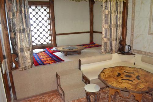 a room with a couch and a table and a window at Ayhan Hotel in Aktobe