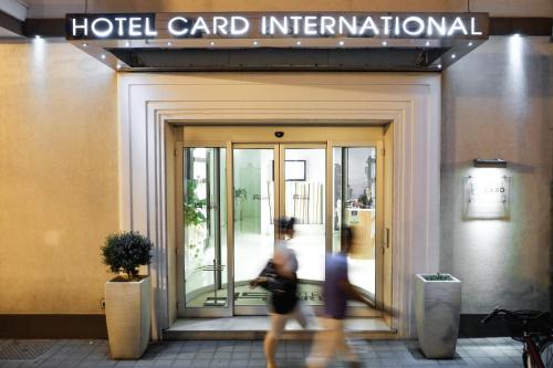 a person walking in front of a hotel card international at Card International Hotel in Rimini