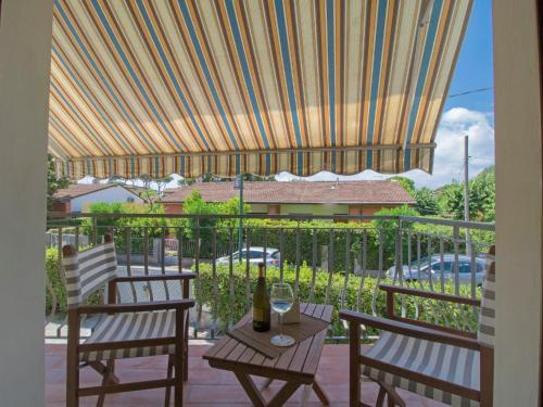 patio z 2 krzesłami i stołem z butelką wina w obiekcie Apartment Il Litorale by Interhome w mieście Forte dei Marmi