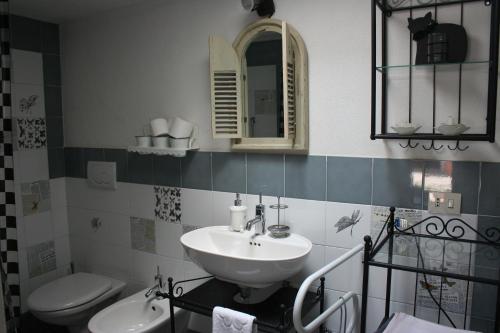 a bathroom with a sink and a toilet and a mirror at I Trulli Di Acquarossa in Cisternino