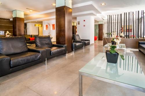 a lobby with black leather couches and a table at Nautic Hotel & Spa in Can Pastilla