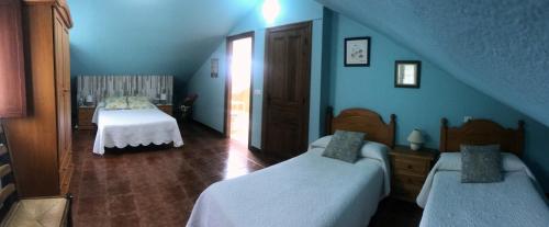 a blue bedroom with two beds and a staircase at Posada de Ajo in Ajo