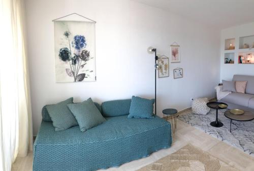 a living room with a blue couch in a room at JACARANDA II Appartement in Mandelieu-la-Napoule