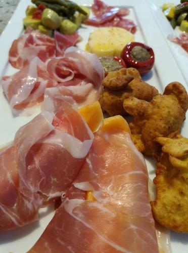 a plate of food with meat and other foods at Chambres d'hôtes Les Iris in Sospel