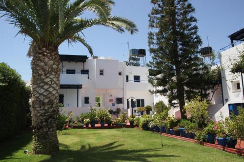 a palm tree in front of a building at Porto Bello Hotel Apartments in Milatos