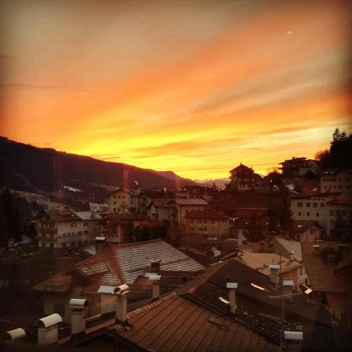 a view of a city at sunset at Hotel La Sorgente in Tesero