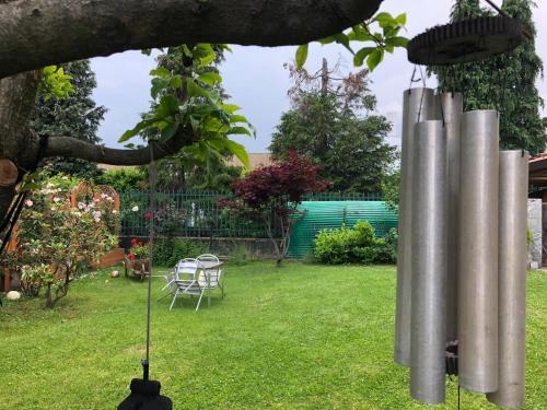 un lampadario a braccio di metallo in un giardino con tavolo e sedie di B&B Sottocoperta a Biella