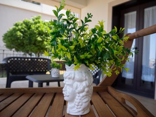 a white vase with a plant in it on a table at Viaggio in Sicilia B&B in Gravina di Catania