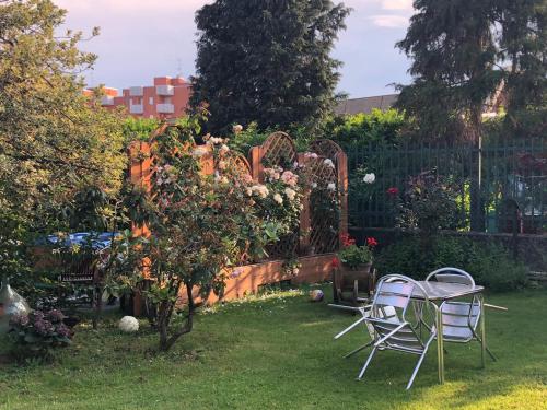 un giardino con due sedie e un tavolo e un albero di mele di B&B Sottocoperta a Biella